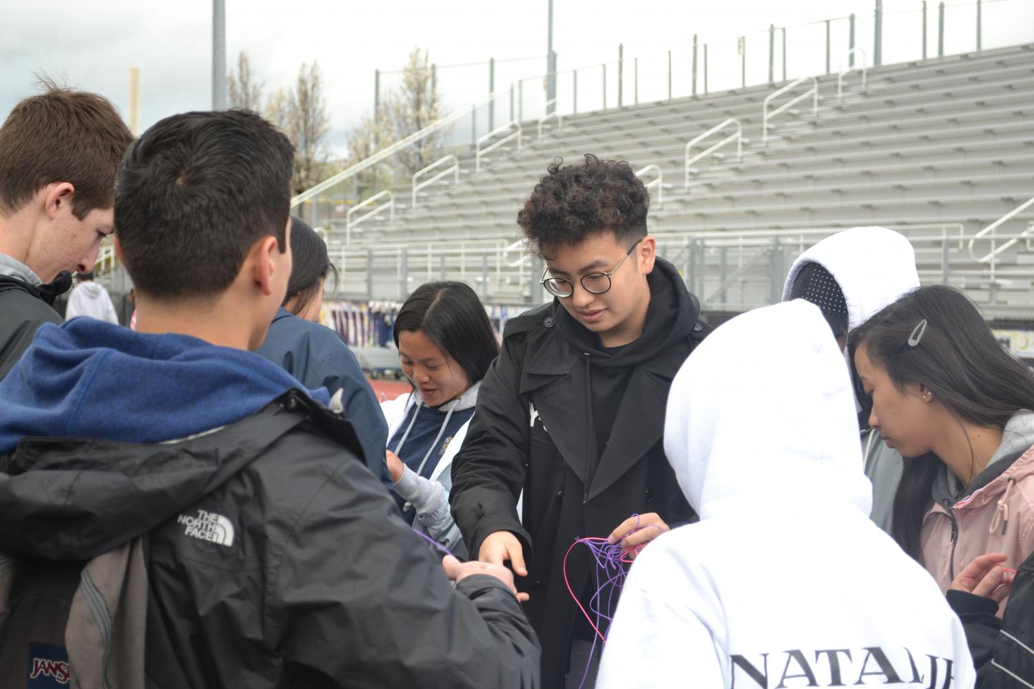 Relay participants gather together in the morning after the Opening Lap to pick up lanyards, onto which one bead is threaded for each lap completed.