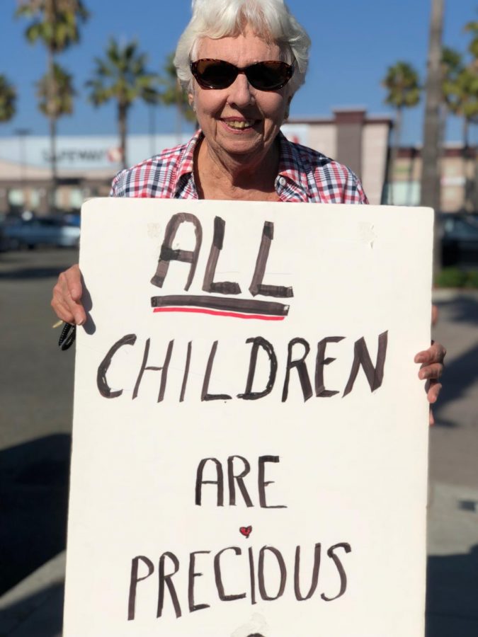 Gwen Watson, co-chairman of the Interfaith Council, holds up a sign she personalized to protest the government’s immigration directives.
