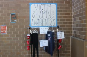 Seniors Kim Shum, Leila Amiri, Katie Moore, Sami Frias and Sam Mass featured a variety of attire, including a crop top and a hoodie, on a clothing rack for their Social Justice project on victim shaming.