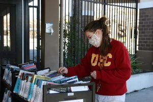 School librarian, Allison Hussenet, looks through books ready for curbside pickup as part of the librarys ongoing efforts to keep remote learners reading.