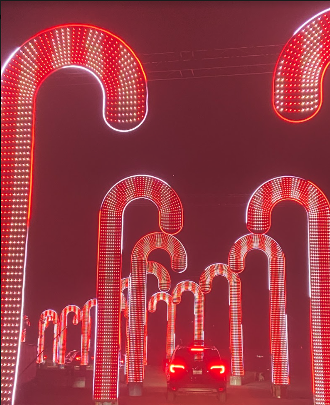 Large light-up displays of stripped candy canes illuminate a driveway at night