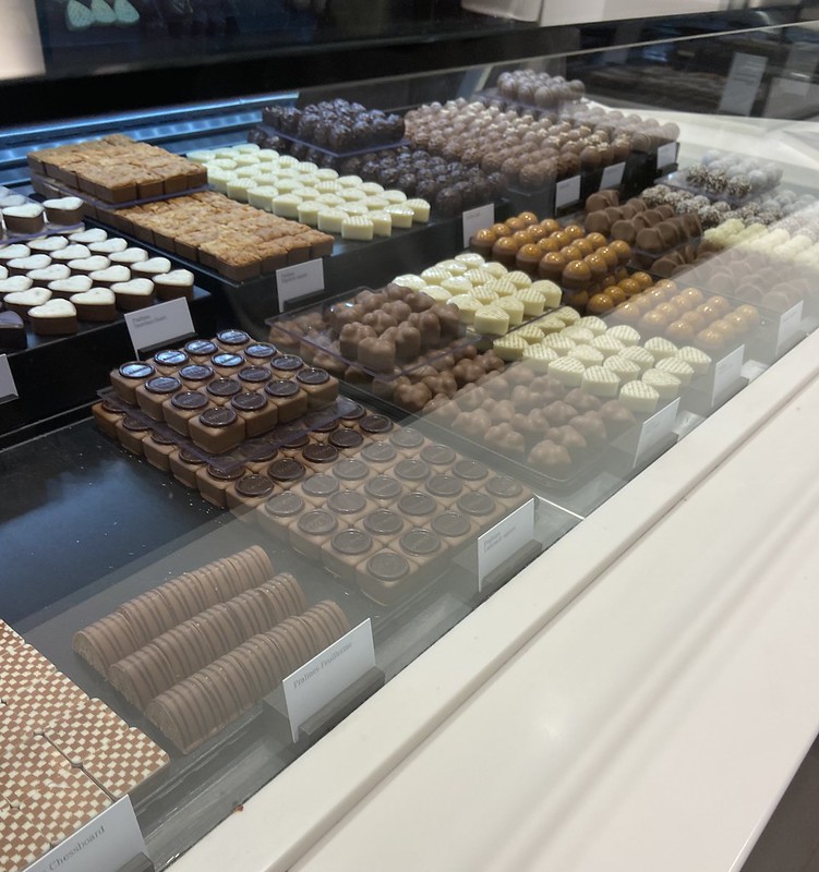 array of various chocolates lined up in the front display of the chocolatier
