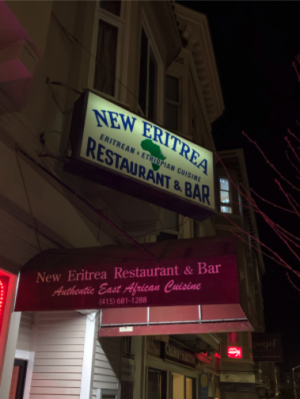 Brightly-lit sign shining in the night which says New Eritrea.