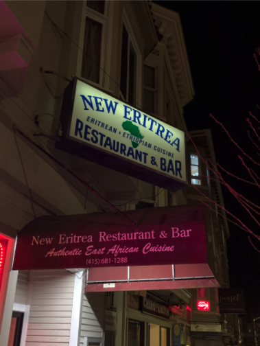 Brightly-lit sign shining in the night which says "New Eritrea."