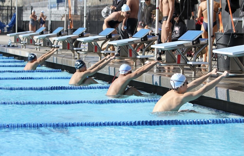 Varsity men get in ready position to swim the 100 yard backstroke.