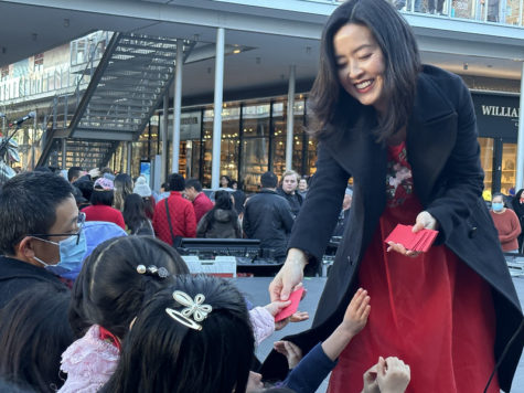One of the event announcers hands out red packets to eager children at the end of the performances.