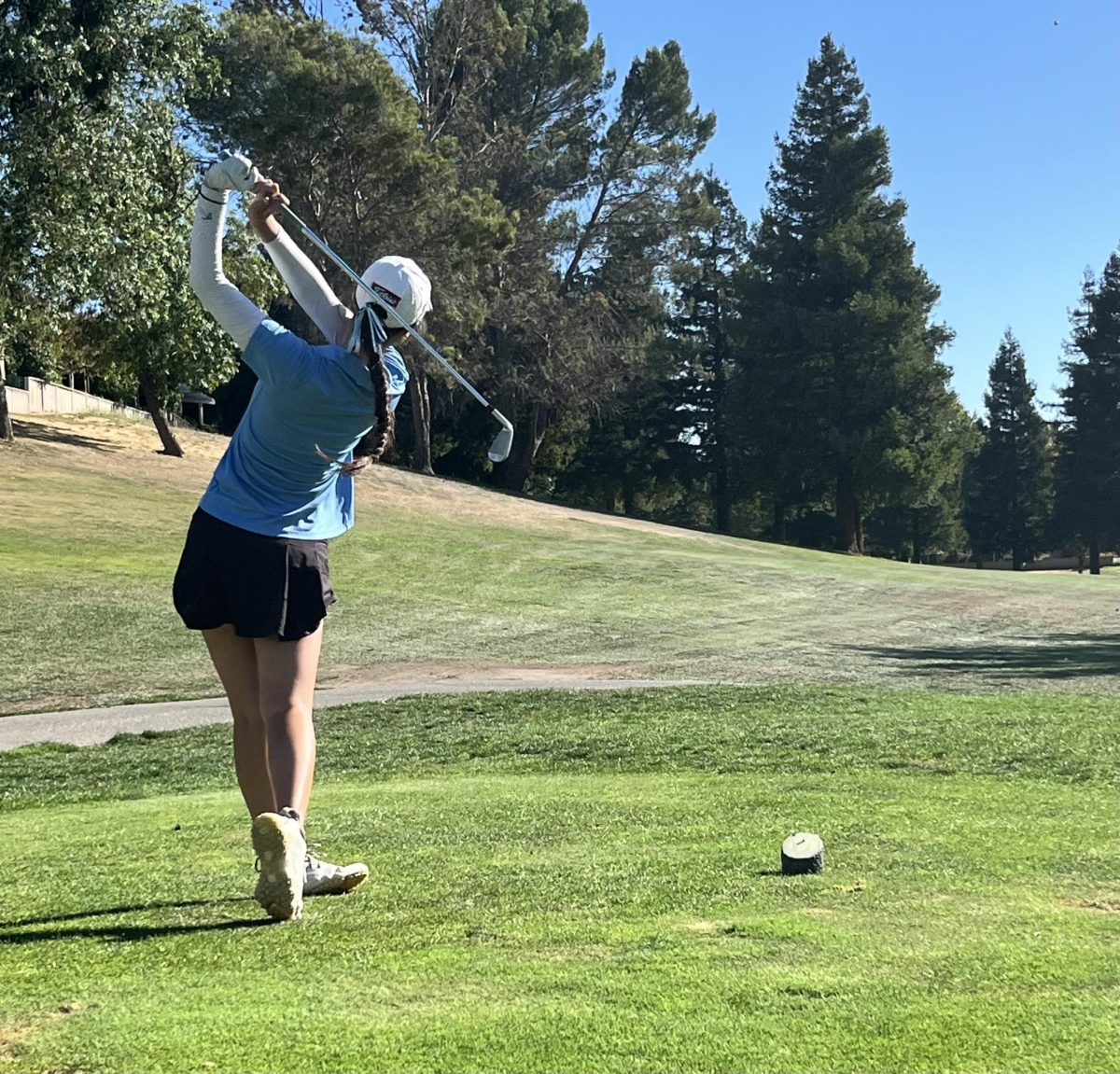 Michelle Ho swings the club and holds her finish after her shot.