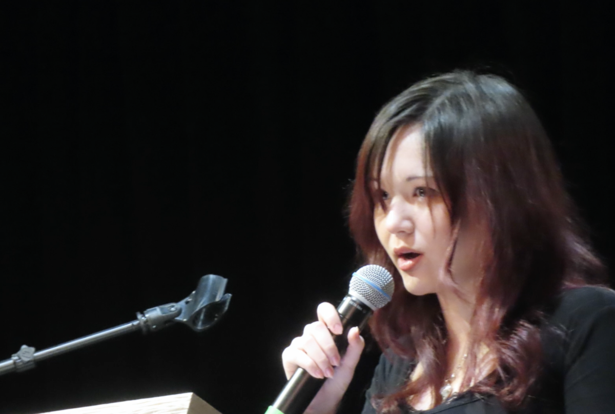 Emily Jingzhu Bennett speaks at an Art Embraces Poetry open mic event.