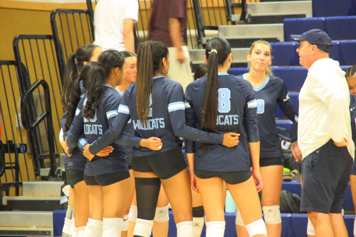Senior Akshara Vermula (2), senior Violet Bothwell (18), senior Cagla Sofuoglu (19), coach Brett Moore and teammates huddle during a game on Sept. 9, 2025.