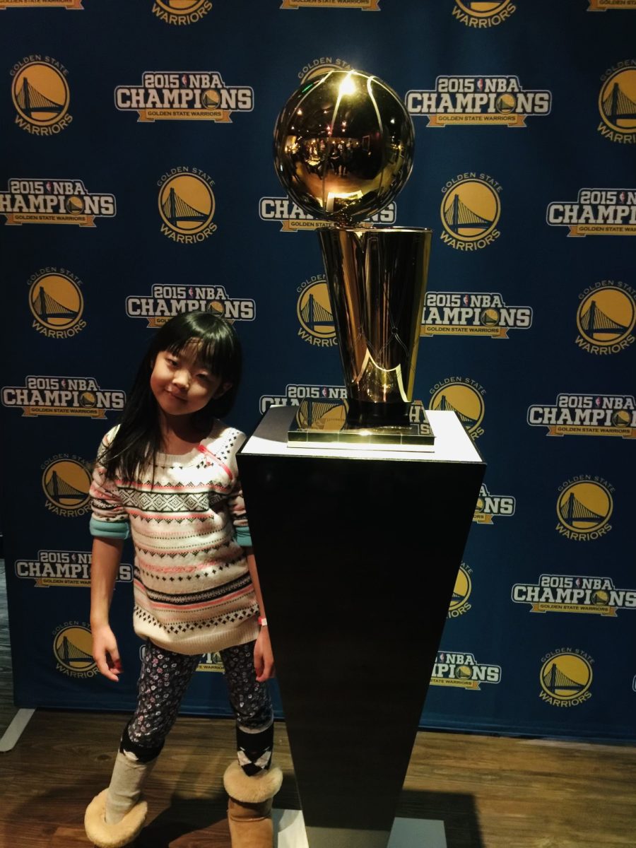 Junior Alina Chen poses with the Warriors’ 2015 NBA Championship trophy 