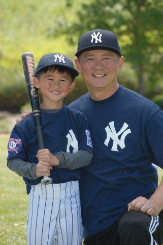Freshman Mikey Wong playing three sports at a young age, posing with his father who frequently coached him.