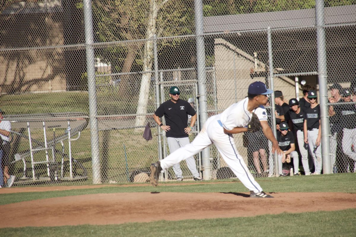 Senior Pitcher Kingston Salinas throws pitch with De La Salle Coach watching on March 27, 2026